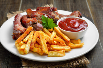 Potato fries, pork ribs and tomato sauce