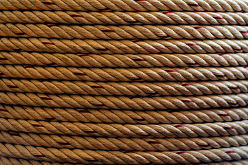 Close-up of a thick, coiled rope with intricate texture and detailed fiber pattern. A strong and...