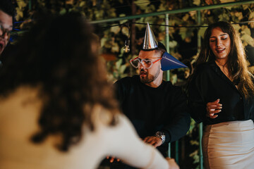 A lively group of friends celebrating at night, wearing festive hats and sharing joyful moments...