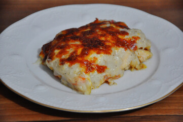 Chicken baked with bechamel sauce on plate