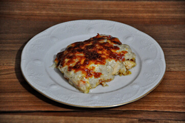 Chicken baked with bechamel sauce on plate