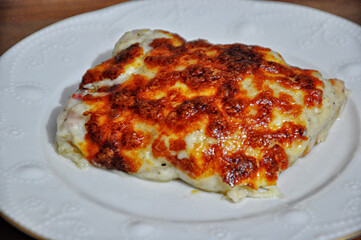 Chicken baked with bechamel sauce on plate