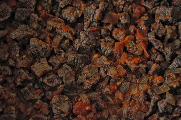 Topped cubes of sauteed meat with tomato sauce