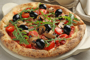 Tasty pizza with mushrooms, black olives and arugula on light grey table, closeup