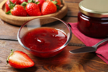 Delicious strawberry sauce and fresh berries on wooden table, closeup