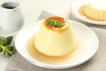 Fototapeta premium Delicious pudding with caramel sauce and mint on table, closeup