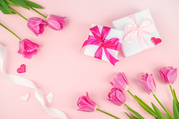 Frame made of gift boxes with ribbon beautiful tulips on pink background. happy mothers day, top view. copy space