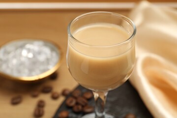 Coffee cream liqueur in glass on table, closeup. Space for text