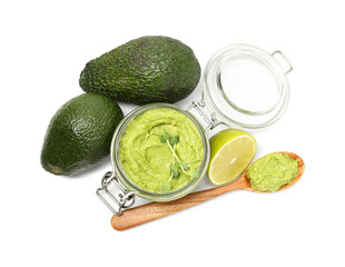 Tasty avocado dip in glass jar, fruits and spoon isolated on white, top view