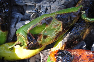 Roasted green and red peppers on the embers