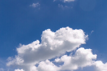 Bright white cumulus clouds are gently drifting across a vibrant blue sky. Creating a serene and peaceful atmosphere. Ideal for backgrounds or representing concepts of nature. Weather, tranquility