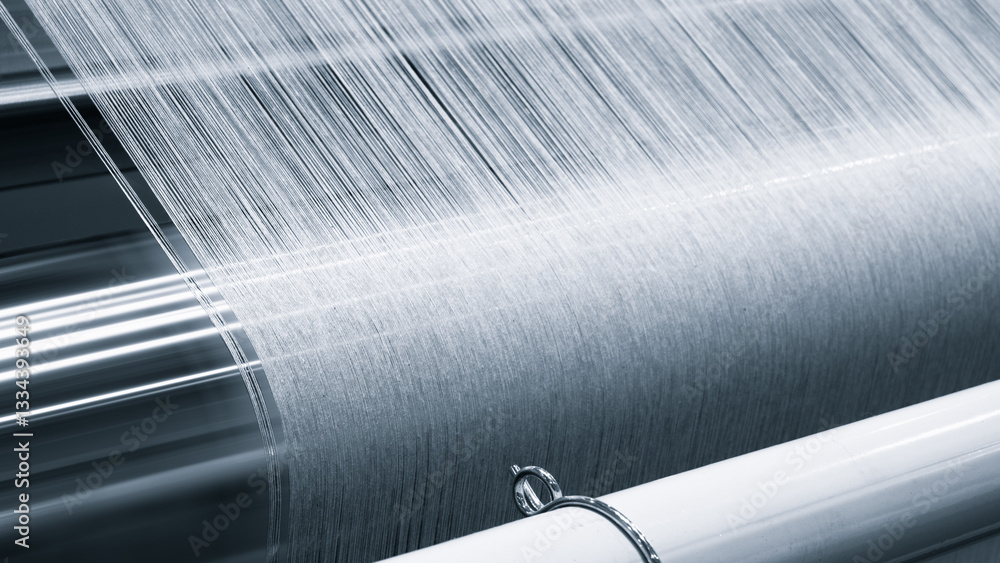 Fototapete a piece of fabric is being woven on a loom. fabric is made of a silky material and is being woven in