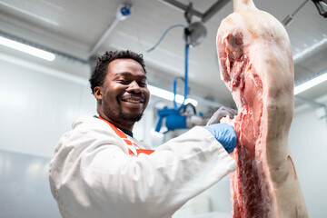 Working in meat industry. Food factory worker cutting pork meat in slaughterhouse.