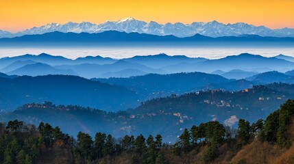 Obraz premium Mountain range view with snow capped peaks and layers of hills under a golden sky light