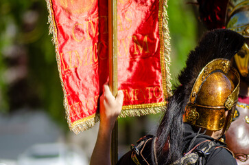 roman legionary carrying the standard of the legion in a historical recreation party.