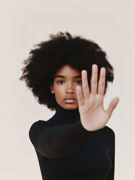 Strong young woman asserts stop gesture against violence, focusing on issues like femicide, racism, and discrimination in a neutral background