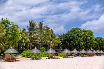 Scenic beach resort. Peaceful oceanside retreat.Scenic tranquil beach adorned with palm trees and...