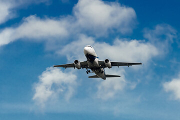Airplane high in the cloudy sky. Travel and air travel concept.