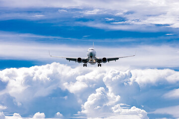 The plane flies through a clear blue sky, surrounded by fluffy white clouds. Travel and adventure...