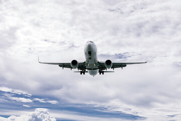 The plane flies through a clear blue sky, surrounded by fluffy white clouds. Travel and adventure...