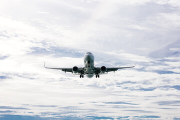 The plane flies through a clear blue sky, surrounded by fluffy white clouds. Travel and adventure concept.