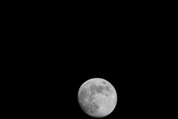 Beautiful full moon on a black background wallpaper. Beautiful full moon in a dark night. Moon wallpaper. Moon background 