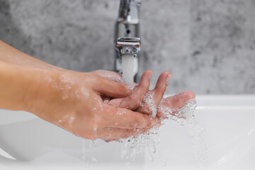 The unrecognizable woman of my hand under running water. The concept of freshness and hygiene rules.