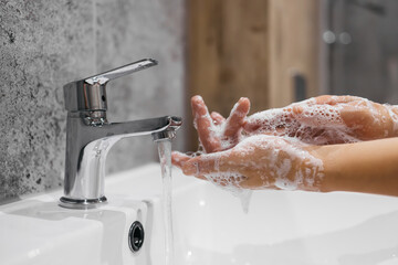A close-up of hands washing their hands with soap emphasizes hygiene, cleanliness and self-care....
