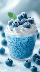 Blueberry dessert with whipped cream and fresh blueberries on top served in a clear glass cup