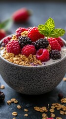 A bowl of yogurt topped with fresh berries and granola on a dark surface in a cozy kitchen setting