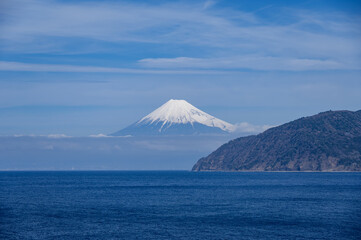 西伊豆の海越しに見た雪化粧している富士山