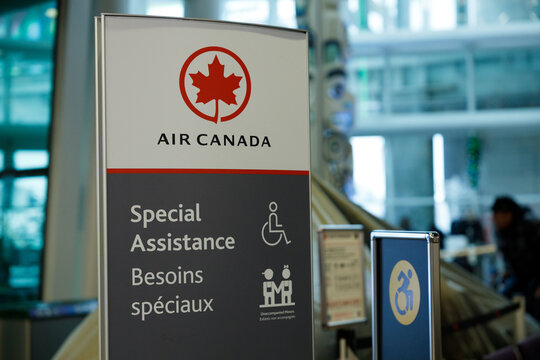 Air Canada special assistance sign at Vancouver Airport showing wheelchair accessibility and unaccompanied minors services