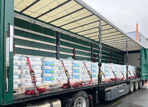 Germany - 03.02.2025: Truck semitrailer with bags of Caparol building mixtures on pallets