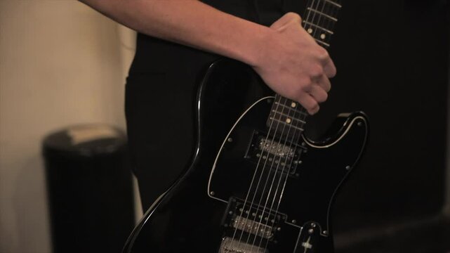Musician holding guitar backstage before going on stage