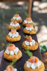 Salmon Roses on Potato Röstis with Cream Cheese Swirl on Wooden Platter