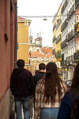A group of various people are casually walking down a city street