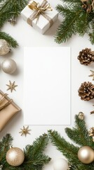 Elegant Christmas holiday background with blank white paper card surrounded by natural pine branches and festive decorations on a clean white surface