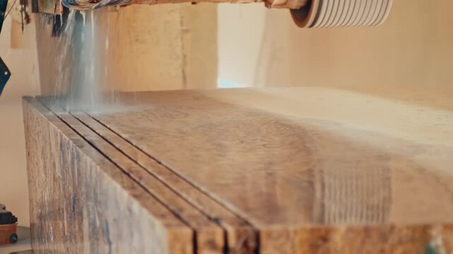Slicing process of a marble block in a multi-blade cutting machine. Rotary discs cut the stone block into thin slabs while water cooling is applied.
