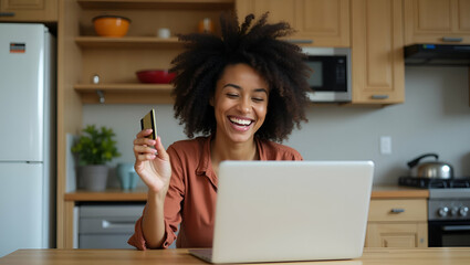 Happy Young African Woman Celebrating Online Shopping Win with Credit Card and Laptop in Kitchen - Excited Customer Receiving Cashback and Bonuses at Home