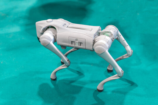 Gray military robot dog at a demonstration with a green background