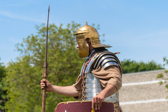 Roman legionnaire in historical armor holding spear and shield 