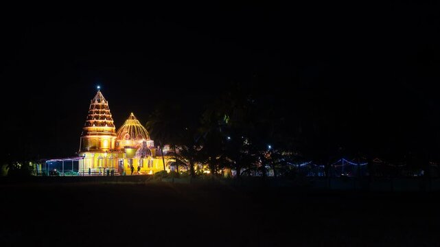 4k Hyper Lapse Timelapse of decorated and lit up Sri Siddhapurush Narayandev temple at Kankabandh Mapusa with locals and devotees visiting it at night during festival