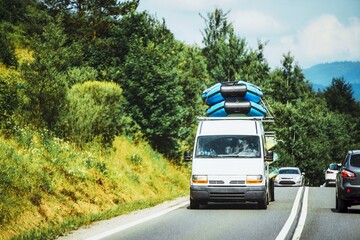 Van transporting boats on road through