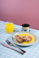 Fried piece of tuna fish on a plate with mashed potatoes in a modern interior with drinks