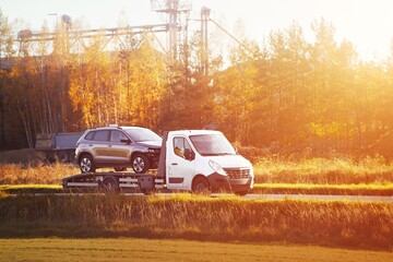 White flatbed truck hauling an SUV