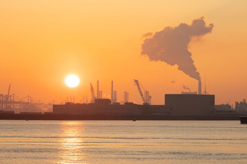 Sunset scenic view of Europoort Rotterdam, gantry crane and smoke background, pollution