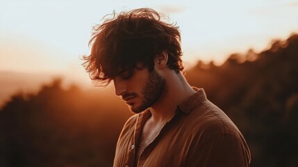 Thoughtful Young Man Contemplating Nature at Sunset in Soft Light