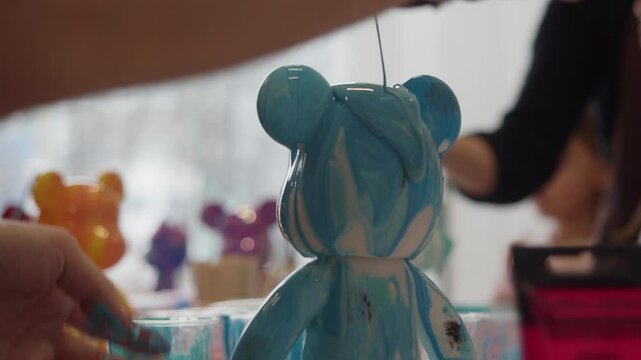 At master class on making toys for children in shape of bears, children paint heads of figures with special paint. toy unique and beautiful.