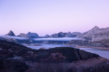 Icy dawn. The warm sky contrasts with the cold emanating from the meadow, covered in frost.