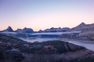 Icy dawn. The warm sky contrasts with the cold emanating from the meadow, covered in frost.